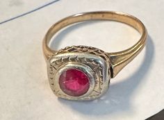 "14K Antique ring man made ruby in a white and yellow setting.  Condition is good, there is minor wear on ruby with age visible with magnification of little consequence-photos show details.  Size 6, wt.- 2.3 grams, approx top 1/3\" by 1/4\".  Lovely old setting open work, filigree  with white gold top and bezel for approx 5mm ruby." Antique Gold Ruby Ring With Bezel Setting, Antique Red 14k Gold Signet Ring, Antique Ruby Signet Ring, Antique Red Signet Ring In 14k Gold, Antique Hallmarked Ruby Signet Ring, Antique 14k Gold Ruby Ring With Center Stone, Antique Yellow Gold Ruby Ring, Antique 14k Stamped Yellow Gold Ruby Ring, Antique Ruby Ring With Bezel Setting