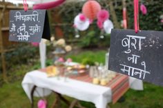 there are some signs hanging from the strings on the table outside with decorations around it