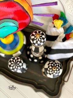 an assortment of colorful knobs on a black tray