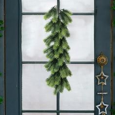 a christmas wreath hanging from the side of a window