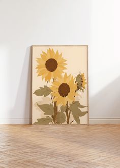 a painting with sunflowers is on the floor in front of a white wall