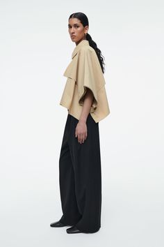 CROPPED TRENCH COAT CAPE - LIGHT BEIGE - COS Oversized Elegant Cape For Spring, Oversized Cape With Cape Sleeves, Chic Outerwear With Cape Sleeves For Spring, Chic Beige Cape For Spring, Chic Spring Cape Outerwear, Chic Fall Capelet, Chic Outerwear With Cape Sleeves For Work, Oversized Beige Cape Outerwear, Chic Oversized Cape For Spring