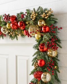 a christmas wreath with red, gold and green ornaments hanging on the front door for decoration