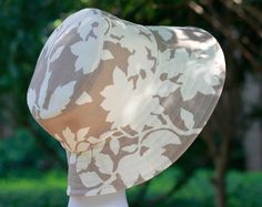 a white mannequin head wearing a hat with leaves on it