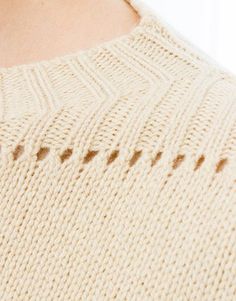 the back of a woman's sweater that has holes in it and is slightly visible