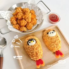 some kind of fried food on a wooden cutting board next to a bowl of ketchup