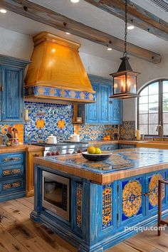 a large kitchen with blue cabinets and an island in the middle is decorated with colorful tiles