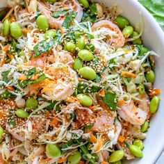 a white bowl filled with lots of food on top of a green table cloth next to a fork