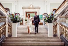 a bride and groom walking down the stairs at their wedding ceremony in an old building