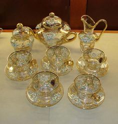 a table topped with lots of glass cups and saucers