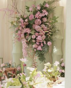 a vase filled with pink flowers sitting on top of a table next to a mirror