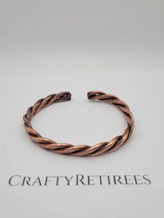 Introducing our Handcrafted Heavy Copper Woven Bracelet, a stunning piece of artisan jewelry designed for both men and women. This bracelet is meticulously crafted from solid copper, featuring an intricate woven pattern that exudes strength and durability. The robust design offers a rustic, timeless appeal, making it a versatile accessory for any outfit, whether casual or formal. Perfect for those who appreciate high-quality craftsmanship, this bracelet not only adds a bold statement to your style but also offers the natural benefits of copper, known for its therapeutic properties. Each piece is handmade, ensuring that no two bracelets are exactly alike, adding a unique touch to your collection. Whether you're looking for a meaningful gift or a special treat for yourself, this heavy copper Adjustable Brown Copper Braided Bracelets, Adjustable Copper Spiritual Bracelets, Adjustable Copper Spiritual Bracelet, Adjustable Spiritual Copper Bracelet, Adjustable Brown Copper Bangle, Adjustable Bronze Copper Bracelets, Copper Braided Bangle Bracelet Gift, Benefits Of Copper, Woven Bracelet