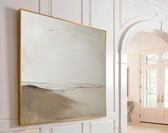 a large white painting hanging on the wall