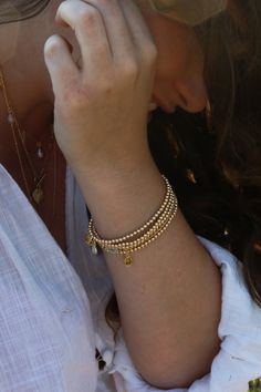 Our Golden Beaded Bracelet is a simple yet radiant addition to any fit representing strength, abundance, and happiness. High-quality 14k Goldfilled beads will last, won't tarnish, and will shine all night long. Choose between one bracelet or layer with our set of two, or stack of three. Golden Beaded Bracelet is handcrafted with 3mm smooth 14k Goldfilled beads on a strong elastic cord. Signature MB gold charm. Each piece is handmade delicately with love and care. All Bracelets are unique and special, variation in color and inclusions in the gemstones are natural. Please take off when swimming, showering, and during hot yoga as water can damage thread. Bathe in moonlight regularly to renew crystals. Enjoy!Light & Love! Golden Beads Bracelet, 14k Gold-filled Yellow Gold Jubilee Beaded Bracelets, Delicate Yellow Gold Beaded Bracelets For Everyday, Classic Bracelets With Tiny Beads For Everyday, Elegant Gold Crystal Bracelet For Meditation, Hand-strung Minimalist 14k Gold-filled Bracelet, Everyday Single Strand Bracelet Jewelry, Minimalist Hand-strung Beaded Bracelets In 14k Gold Filled, Minimalist Hand-strung 14k Gold Filled Beaded Bracelets