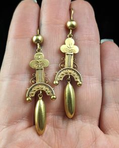 "A truly stunning pair of antique 15ct gold Etruscan revival style earrings. They are dangly earrings the tops made up of a trefoil or club shaped column with delicate cannetille detailing and wirework to the sides. Suspended from here there is a smooth polished pendant adding drama and movement to the earrings. The Etruscan revival manner was also known as the archeological movement, jewellery inspired by the archeological finds in Italy during an excavation in the mid to late 19th century. There is just so much detail on this pair and they really are truly exceptional in design and craftsmanship.  No jewellery box is complete without a good pair of antique drop earrings and these make a wonderful gift for the lover of antique jewels. They are hollow so are lightweight and easy to wear. M Archaeological Finds, Gold Cross Pendant, Aesthetic Stuff, Dangly Earrings, Gift Wrapping Services, Wire Work, Style Earrings, Vintage Jewellery, Victorian Era