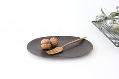 a plate with some food on it next to a fork and flower potted plant