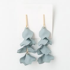 two pairs of blue flower shaped earrings on a white card with clippings for each earring