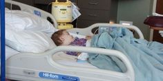 a small child laying in a hospital bed