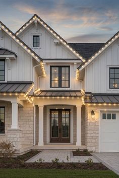 a white house with christmas lights on the front and side of it's windows