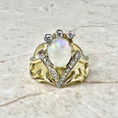 CLEARANCE - 40% OFF! Beautiful vintage 18 karat yellow and white gold ring featuring a fine natural opal cabochon, the birthstone for October ! The gemstone weighs approximately 2 carats, and is surrounded by 12 diamonds weighing approximately 0.30 carat.Diamonds are approximately G-H color SI-I1 clarity. Weighs 7.6 grams. Size 7.25 US / O 1/2 UK / 55 FR. > Ring sizing not included.This ring can be sized to fit most fingers.If you need to size this ring, please contact us before placing the orde Gold Opal Multi-stone Ring, Unique Gold Opal Ring With Multi-stone, Unique Multi-stone Opal Ring In Gold, Collectible Gold Opal Gemstone Ring, Collectible Gold Opal Ring With Gemstone, Gold Multi-stone Opal Ring With Oval Cabochon, Collectible Gold Opal Rings, Gold Opal Ring With Oval Cabochon, Gold Opal Ring With Oval Cabochon Birthstone