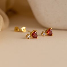 Indulge in the captivating allure of our Garnet Heart Drop Studs, your new go-to choice for romantic evenings and special occasions. Crafted with deep red, heart-shaped garnet gemstones, these exquisite earrings effortlessly radiate femininity and elegance, complementing any outfit with their timeless charm ♡ Material: High Quality Solid 925 Sterling Silver Finish: 18K Gold ∙ Sterling Silver Featuring ~7mm CZ Garnet Heart Charm with ~4.5mm CZ Diamond Drop Stud Earrings Sold as a pair Model showc