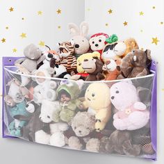 a plastic bin filled with stuffed animals on top of a white wall next to stars