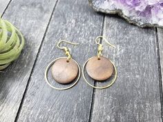 These lightweight dangle earrings feature 18mm dark brown unfinished wooden discs dangling inside 25mm gold plated brass hoops. The ear wires are made of hypoallergenic gold plated surgical steel, making these earrings safe for sensitive ears! They are super lightweight, each weighing only 0.1 ounce. They measure approximately 1.75 inches from the top of the ear wires to the bottom of the gold hoop.Domestic shipping is always free here at Mayamadethis!When will my item ship? Every single item he Wooden Round Earrings For Gifts, Round Wooden Earrings For Gifts, Round Wooden Earrings As Gift, Wooden Round Earrings Gift, Brown Round Earrings For Pierced Ears, Brown Wooden Drop Earrings, Brown Wooden Round Earrings, Brown Wood Drop Earrings, Everyday Brown Wood Earrings