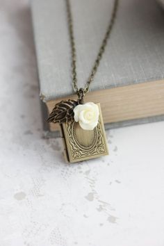 This is a vintage inspired antique brass book locket necklace. The locket pendant has lovely etched designs and there are two charms including a resin rose and a rustic antique brass leaf charm. You can choose a black or cream rose.This necklace can easily be adjust to your exact preferred length. Please select your chain length at checkout! Details: ~ Locket measures approx 1" x 3/4" and has two oval frames for mementos, pictures or can be a special secret hiding spot for your own personal trea Deep Red Wedding, Secret Hiding Spots, Book Locket Necklace, Gold Orchid, Resin Rose, Picture Locket, Book Locket, Wedding Unique, Filigree Necklaces