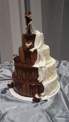 a three tiered wedding cake with chocolate icing and white frosting on top