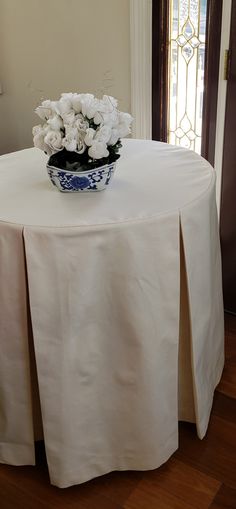 a vase with white flowers sitting on top of a table in front of a door