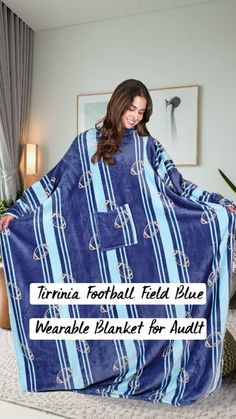 a woman holding up a blue blanket in her living room with the words virginia football field blue whale blanket for adults