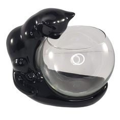 a black cat figurine sitting on top of a fish bowl