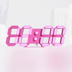 a pink clock sitting on top of a table