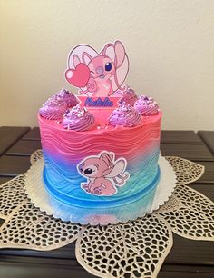 a pink and blue cake sitting on top of a table