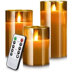 three lit candles with remote controls next to each other