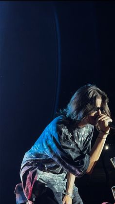 a man standing on top of a stage holding a microphone in front of his face