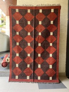 a red and brown quilt hanging on the wall