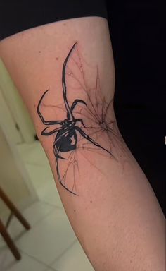 a black and white spider tattoo on the leg