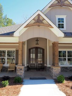 the front entrance to a house with stone and wood trimmings on the windows