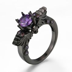 Violet Claw-Set Gothic Skull and Wings Ring Unique Design Embrace the edgy allure of the Violet Claw-Set Gothic Skull and Wings Ring. This gothic-inspired piece features a striking skull and wings design that is sure to turn heads. Stunning Gemstone At the center of this captivating ring lies a rich violet brilliant-cut gem, securely set in an intricate claw setting. The purple gem adds a touch of elegance and sophistication to the punk vibe. Quality Materials Item Type: Fashion Rings Metal Type Skull Wings, Skeleton Ring, Gothic Engagement Ring, Neo Gothic, Gothic Ring, Purple Gems, Gold Skull, Vintage Skull, Gothic Rings