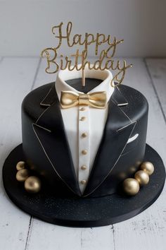 a black and gold birthday cake with a tuxedo on top