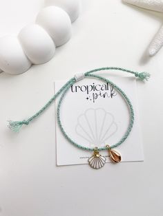 🐚 Sandy toes and sea shell dreams! This beautiful summer bracelet features 18K gold plated charms in a handmade adjustable glitter cotton rope cord. 😎 ITEM DETAILS  🌴 18K Gold plated charms 🌴 Cotton cord rope 🌴 Nylon cord All of our bracelets are handmade with high quality materials. The listing is for one bracelet, images showing more than one are an example of how they would look stacked with other bracelets. If you have any questions, please feel free to message me. CARE TIPS 🤍 Keep your jewelry dry and away from perfumes or any harsh chemicals 🤍 Store your jewelry separately, and avoid wearing it if you are going to work out. Thank you so much for visiting my shop! 🤍 Have fun creating your favorite combinations and enjoy your new jewelry!  Follow me on instagram: @tropicalpink_ Adjustable Gold Charm Bracelet For The Beach, Adjustable Gold Charm Bracelet Ocean-inspired, Handmade Gold Braided Bracelet For Vacation, Gold Shell-shaped Bracelet For Vacation, Adjustable Gold Charm Bracelet With Starfish Charm, Adjustable Gold Beaded Bracelets For Beach Season, Adjustable Beaded Bracelets With Charms For Beach, Gold Beaded Ocean-inspired Bracelets For Vacation, Gold Beaded Bracelets For Beach Season Gifts