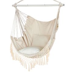 a white hammock chair hanging from a wooden pole with a pillow in it