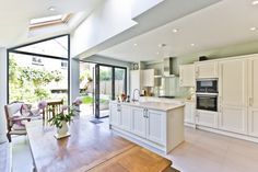 an open kitchen and dining room area with large sliding glass doors leading to the backyard