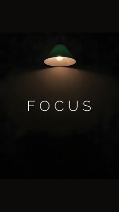 the word focus is lit up in front of a black background with a green lamp