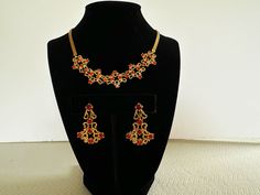 "Vintage red rhinestone necklace and earring set by Garne.  This Art Nouveau/Edwardian style matching set is a high quality example of collectible costume jewelry.  From the 50s, the necklace/choker measures approximately 15 1/2\".  The earrings are approx. 1 1/4\" in length and are screw back.  It has all it's rhinestones, which are a rich ruby/cranberry red, and are prong set.  Made of a smooth, shiney gold tone metal, which has never tarnished.  It is unmarked, but has the hallmark of Garne.  In excellent vintage condition.  I do not have the original box.  A fun and elegant Christmas or Holiday jewelry set, or unique Christmas gift for a friend.  Thanks for looking! FREE SHIPPING in US INTERNATIONAL SHIPPING - if shipping costs are less than estimated, the difference is refunded." Red Jeweled Jewelry Sets For Party, Red Jeweled Jewelry Set For Celebration, Festive Red Necklaces With Matching Earrings, Festive Red Necklace With Matching Earrings, Festive Red Jeweled Jewelry Sets, Red Jeweled Jewelry For Evening, Red Evening Jewelry, Elegant Red Jewelry Sets For Festive Occasions, Red Temple Jewelry Necklaces For Formal Occasions