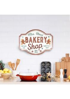 there is a sign that says bakery shop on the wall above the kitchen counter, with lemons and other cooking utensils