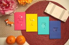 three oranges sitting on top of a table next to some cards