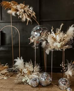 an assortment of silver and gold decorations on display in front of a black wall with mirrors