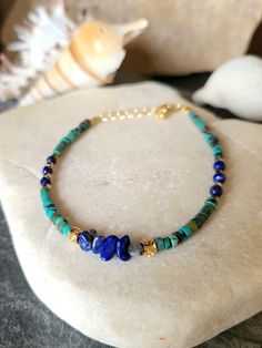 This delicate bracelet is made of small heishi roundels in real turquoise and lapis lazuli. I decorated them with fine gold-plated round beads and golden hematites. The round beads, the clasp, the rings and the chain are gilded with fine 24K, 3 micron gold made by a professional gilder. The bracelet measures from 16.5 cm to 19 cm thanks to the extension chain. Stone size approximately 3.3 mm. Boho chic bracelet, women's gift. To wear alone or combined with other bracelets. You can find a bangle Blue Bohemian Heishi Beads Jewelry, Dainty Blue Bracelets With Natural Stones, Bohemian Blue Beaded Bracelets With Gemstone, Bohemian Blue Gemstone Bracelets, Blue Bohemian Gemstone Bracelets, Dainty Blue Gemstone Beaded Bracelets, Blue Dainty Gemstone Beaded Bracelet, Adjustable Lapis Lazuli Beaded Bracelets Bohemian Style, Handmade Gold Beaded Lapis Lazuli Bracelets